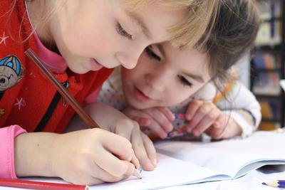 Two little girls writing